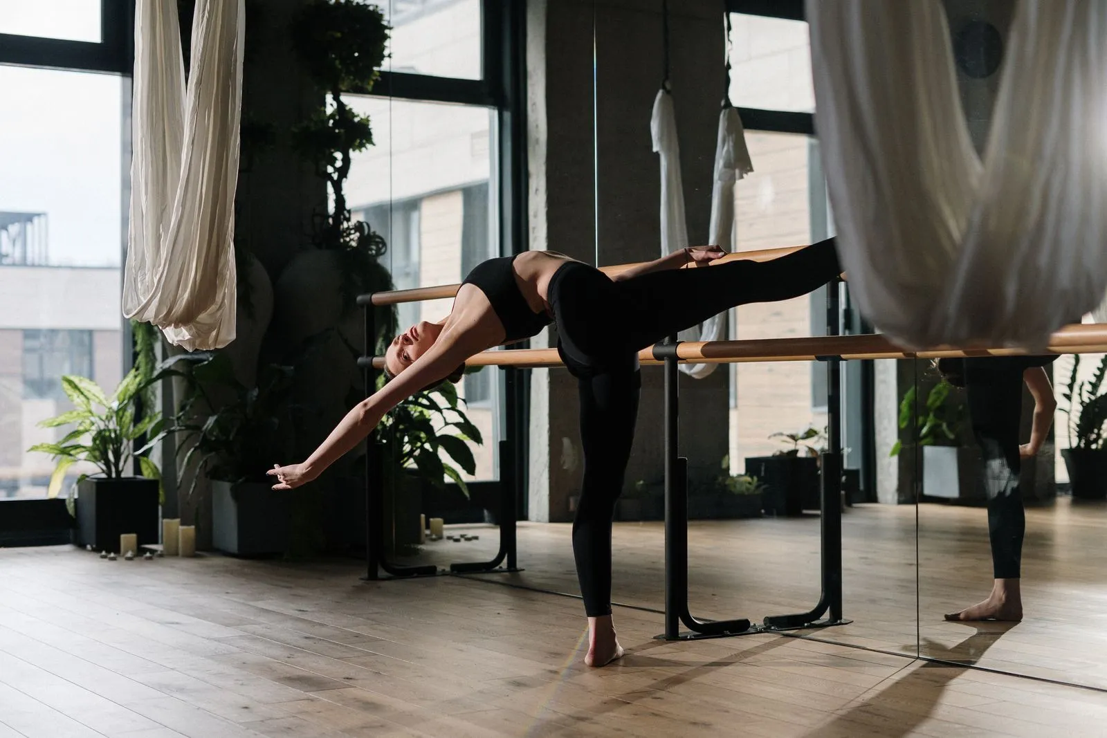 A woman stretches gracefully during a yoga session in a contemporary studio.